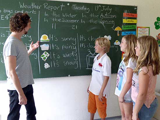 Sch&uuml;ler mit Lehrer an Schultafel